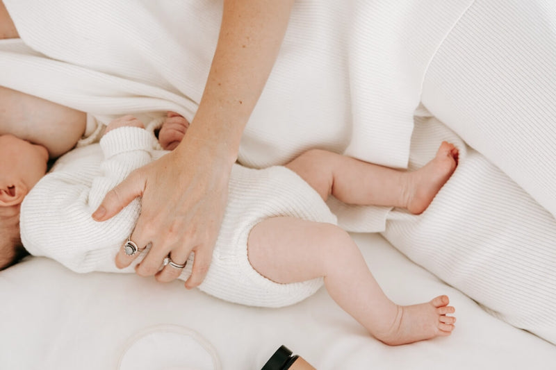 A mother lying down with her newborn baby