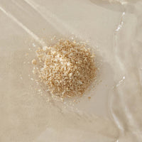 A small pile of Bare Mum Sitz Bath Salt on a textured beige surface