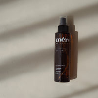 Bottle of Mere botanicals Magnesium Spray on a beige background