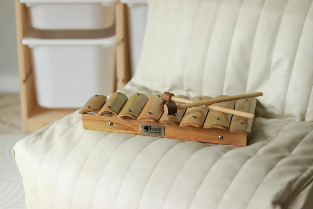 Wooden xylophone on a white cushion with a blurred background