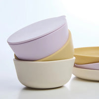 Set of pastel-colored Rommer silicone children's dinner set bowls with lids on a light background