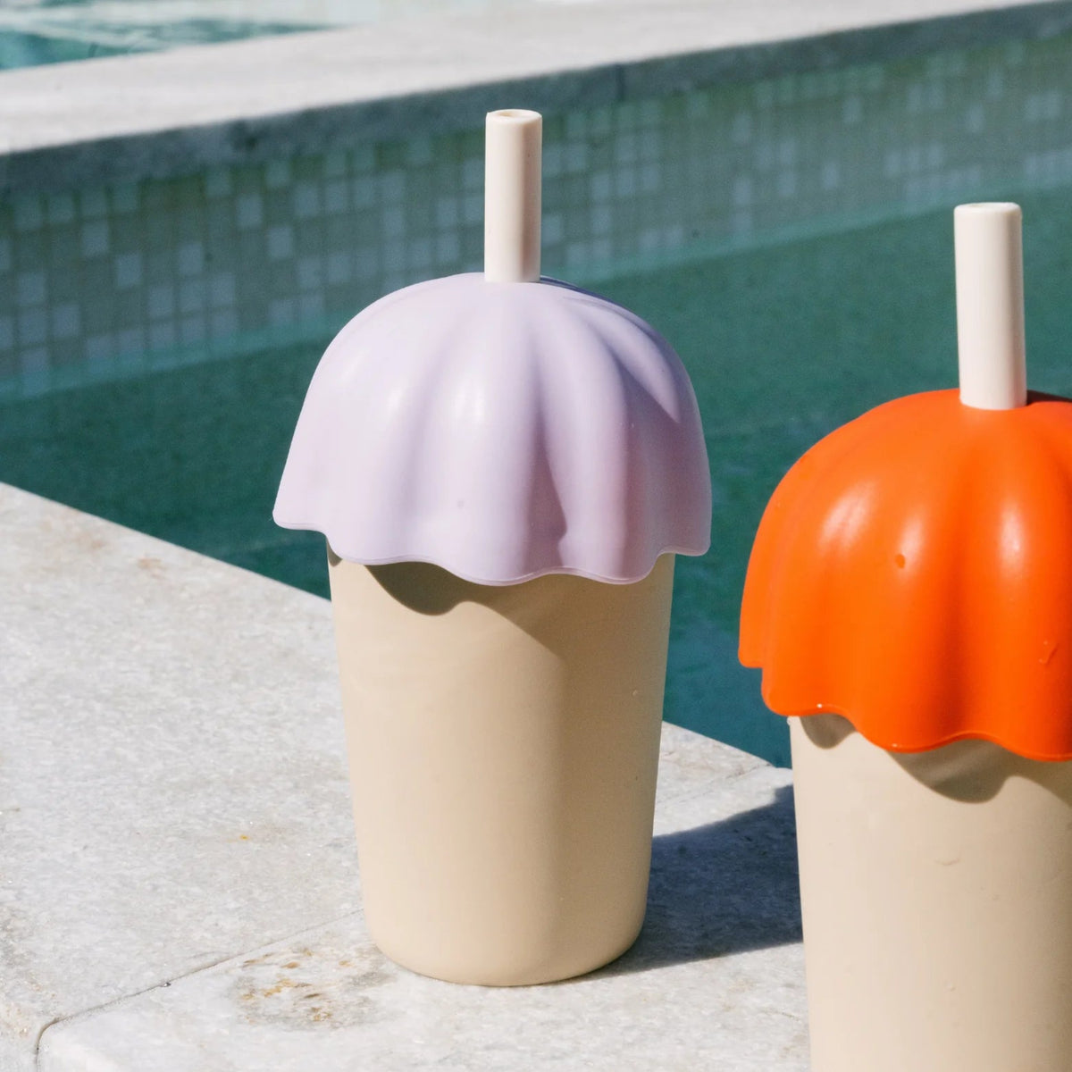 Rommer childrens smoothie cup in lilac next to a swimming pool