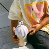 Child holding Rommer children's smoothie cup lilac