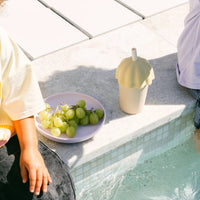 Rommer children's smoothie cup next to a swimming pool