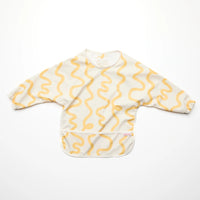 Rommer smock bib with yellow wavy pattern on a white background
